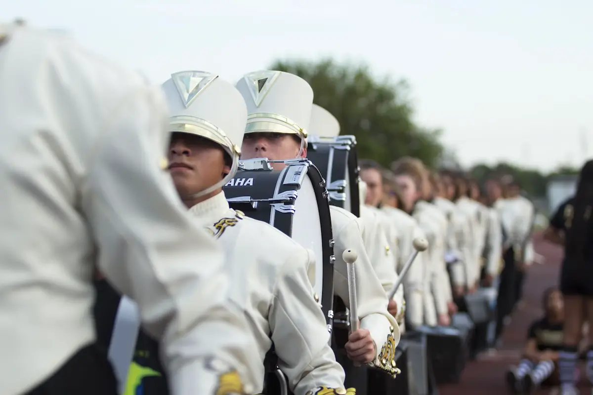 Drumline Students Marching with Bass Drums